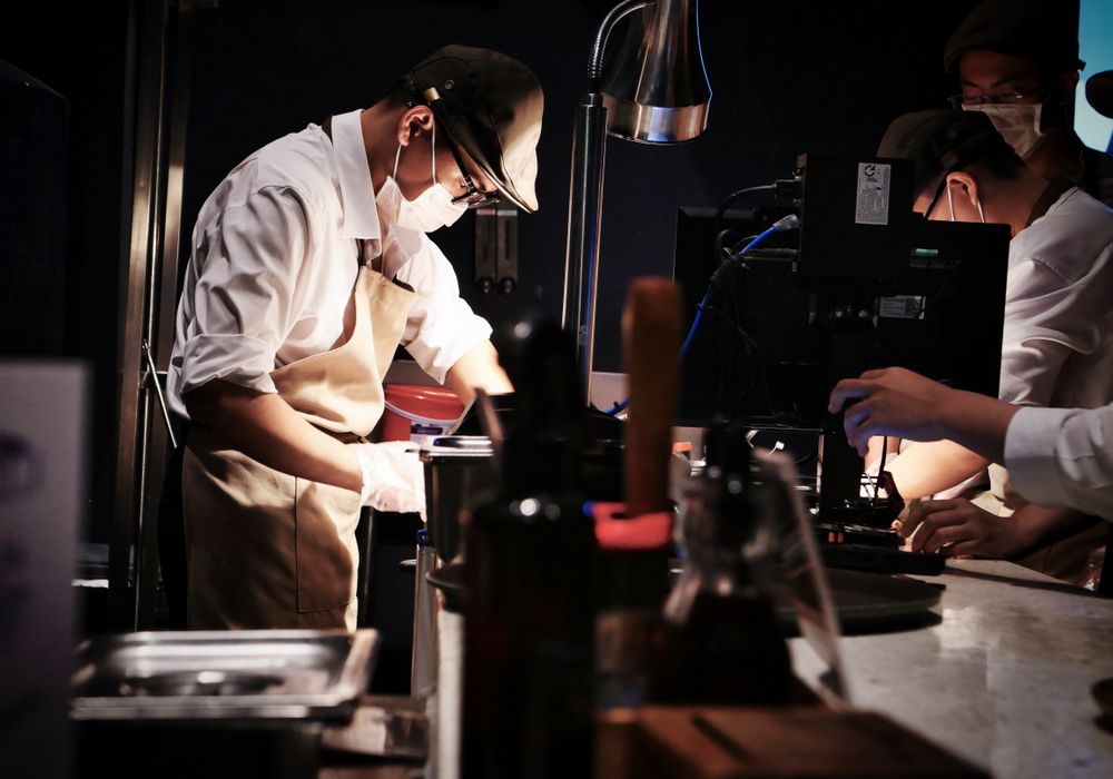 La cuisine et la brigade en plein service, gestes précis et plats en cours de dressage.